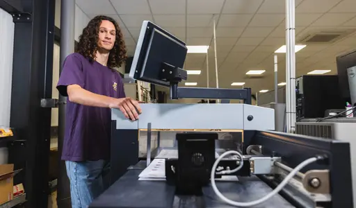 Un technicien spécialisé en impression numérique devant sont poste de travail.