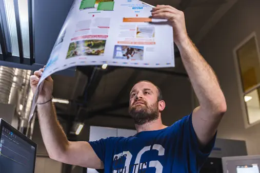 Un technicien examine un document après impression.